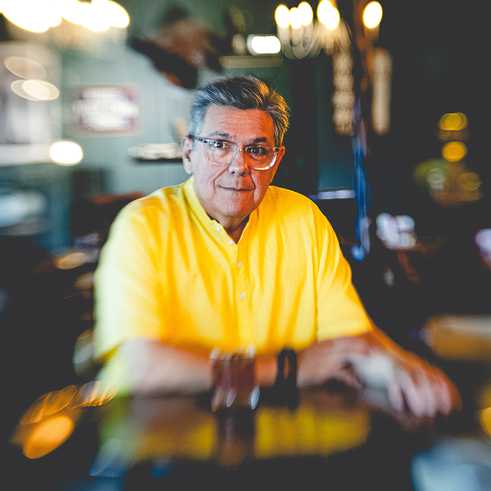 A high-contrast photo of Blacky V in a yellow shirt with blurred edges